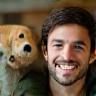 Ben smiling with his dog at home